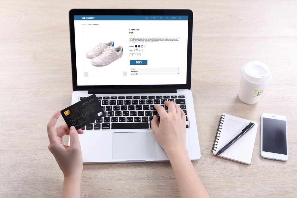 Woman use ecommerce webshop for buy shoes with holding credit card